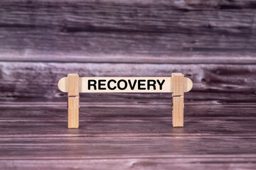 Recovery symbol. Wooden stick held by Clothespins, beautiful Realistic Grunge Wooden Background. Business and Recovery concept with copy space