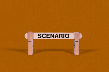 Fototapeta premium Scenario symbol. Wooden stick tightened by Clothespins, beautiful Orange color Backdrop. Business and Scenario concept with copy space