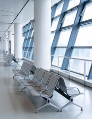Empty Modern Airport Terminal Waiting Area with Rows of Seats and Large Windows