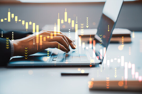 Hands typing on laptop with falling stock chart and downward trend indicators in office showing financial crisis and market collapse concept. - Powered by Adobe