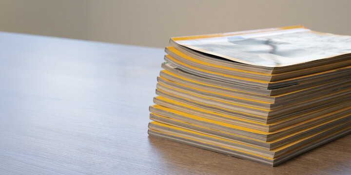 Magazines publication stack of printed magazines on table representing publishing, editorial work, print media, brand marketing, subscriptions, copy space for headlines.