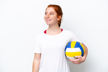 Young caucasian reddish woman playing volleyball isolated on white background thinking an idea while looking up