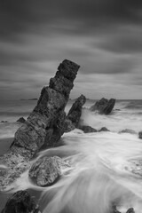 Monochrome of stormy seascape with jagged rocks and crashing waves on the dramatic sky in eastern of Thailand
