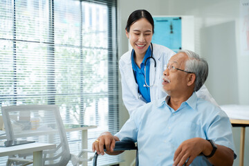 Obraz premium Young Asian female doctor in white coat consulting with senior male patient in the clinic.Healthcare professional using tablet to discuss medical results or treatment options.older elderly health care