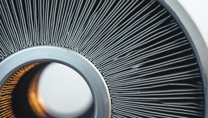 Close view of a circular metal fan part showing thin blades and a central opening against a light background