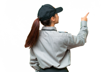 Young safeguard woman over isolated chroma key background pointing back with the index finger