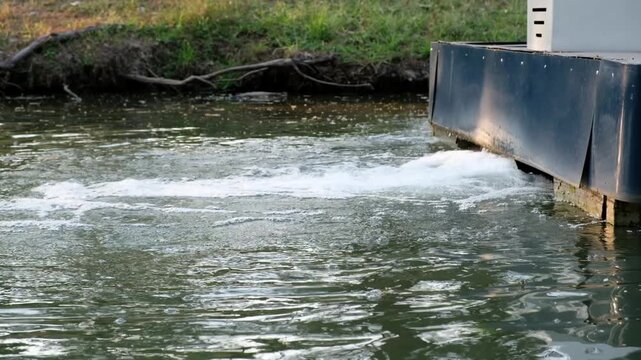 Water flowing from a boat's stern, creating ripples and foam on the surface