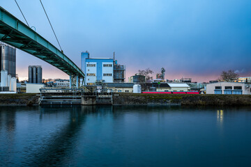 The Gersthofen industrial park is a chemical and industrial site with futuristic-looking buildings and silo facilities. The green bridge construction spans the Lech Canal