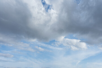 Overcast sky with dramatic dark grey and white clouds contrasting against patches of bright blue sky
