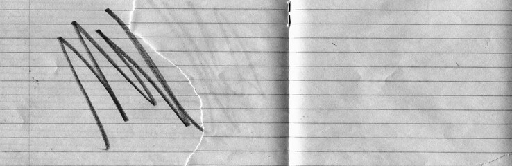 Lined notebook paper texture with fold crease, torn edge and black expressive pencil marks. Minimal yet emotional background combining stationery surface with abstract gesture and contrast