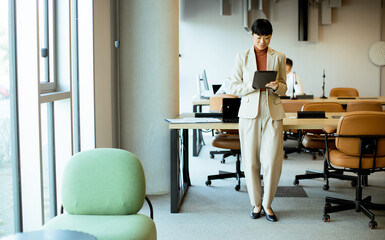 Business woman using tablet in modern office with open workspace
