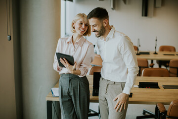 Young professionals smiling and discussing ideas in a modern office setting
