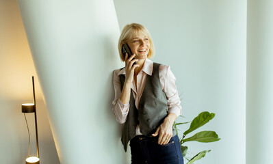 Woman smiling while talking on smartphone in a modern office setting
