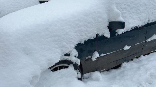 Parked cars at the street after huge snowfall in Moscow, Russia. Automobiles covered with snow. Winter concept.