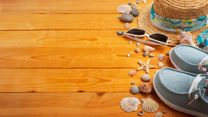 Holiday vacation travel planning background of straw hat, sunglasses, moccasins and shells on natural wood planks