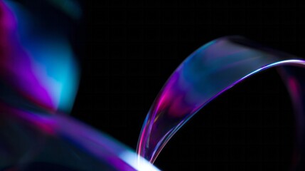 Iridescent flowing ribbon with vivid purple and blue hues on black background.