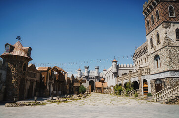 A medieval-style stone castle with ornate towers and defensive walls under a clear blue sky in Armenia