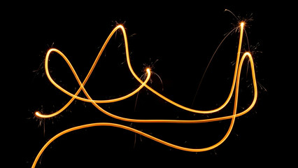 Captivating light trails from a sparkler creating an abstract golden pattern on a dark background
