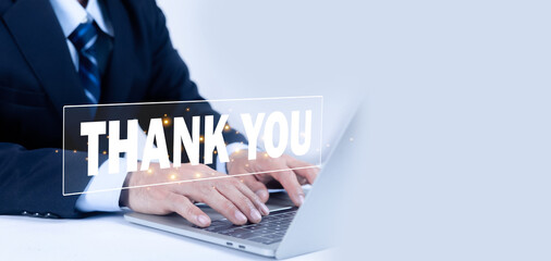 A businessman in a suit works on a laptop with a glowing thank digital banner overlay. This image represents professional gratitude, customer appreciation, or the closing of a successful presentation.