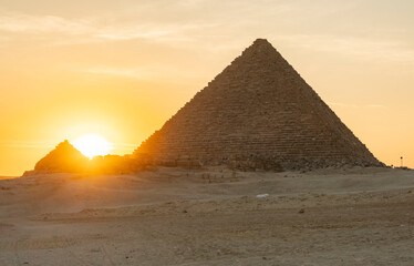 Sunset view of pyramid in desert with setting sun in background near Giza, Egypt