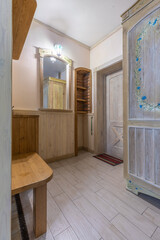 Rustic hallway interior with hand-painted wardrobe and wooden door