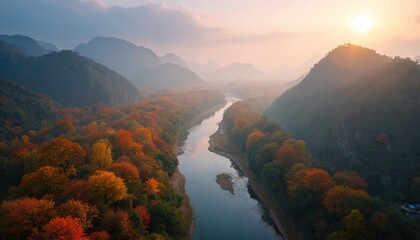 Aerial scenic view of autumn forest with colored trees near river. Mountains with fog on background. Beautiful tranquil sunlight landscape shot from above at sunrise or sunset.