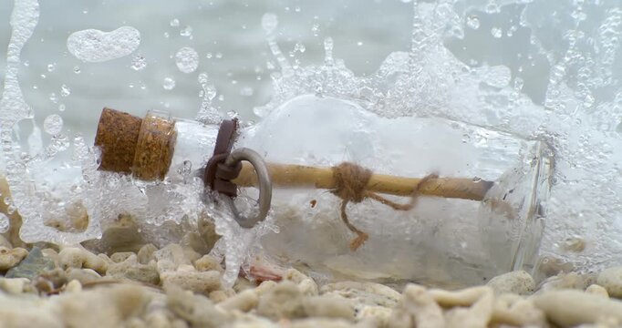 Message in the bottle on a sand beach. Shot on super slow motion camera 1000 fps.