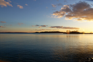 Sunset over Balaton Lake in Hungary with calm waters and distant hills