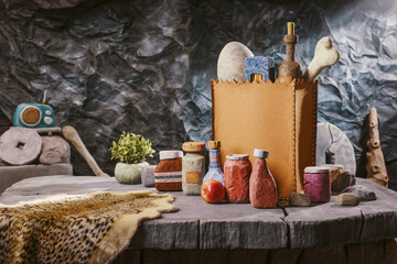 Stone Age grocery shopping: grocery bag and fresh food on a table