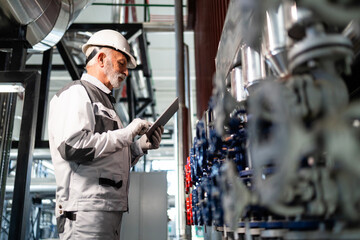 Senior engineer checking plant system using tablet