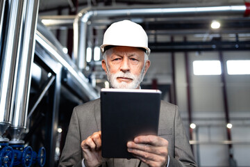 Senior engineer using tablet in industrial plant