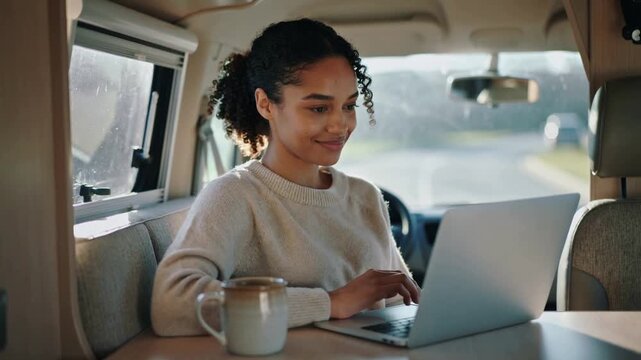 entrepreneur young Woman working on laptop inside van 