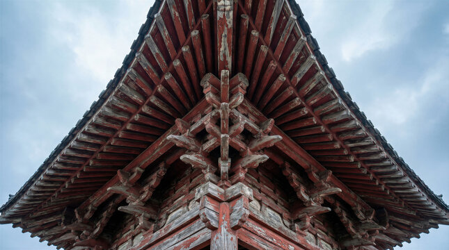 Architecture roof traditional ancient temple asian wooden red chinese structure details. Low angle view of weathered eaves and intricate dougong brackets of a historical building against the sky.