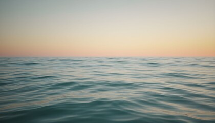 Obraz premium Calm ocean waves gently ripple at serene sunset on peaceful water surface