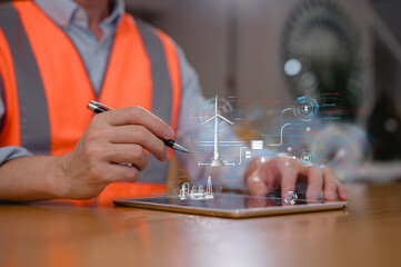 Engineer in safety vest operating tablet with virtual wind turbine and smart energy system interface. Concept of renewable energy, Industry 4.0, digital engineering, and sustainable technology.