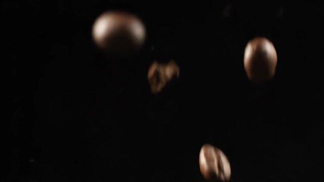 A vibrant close-up view of numerous dark roasted coffee beans in motion, creating a rich and aromatic visual texture.
