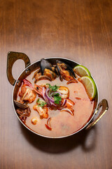 mixed seafood tom yum thai curry soup indoors ina a phuket thailand restaurant