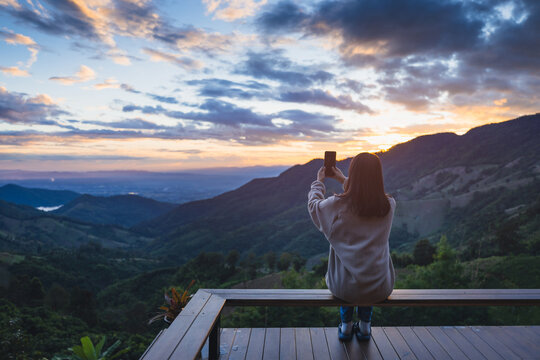Traveler asian woman relax on balcony in homestay resort Doi Sakad mountain valley at sunset sky in Pua Nan Thailand Winter travel holiday vacation concept