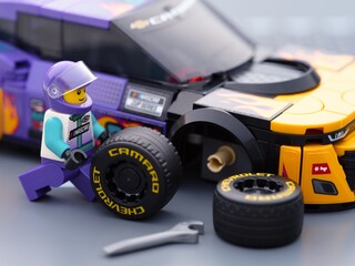 Obraz premium Tambov, Russian Federation - January 02, 2026 Lego driver minifigure changing wheel of the Lego NASCAR Next Gen Chevrolet Camaro ZL car. LEGO Speed Champions.