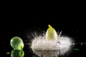 Two colorful water balloons squirting