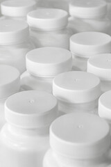 Empty unlabeled white plastic medicine jars