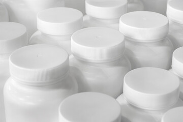 Empty unlabeled white plastic medicine jars