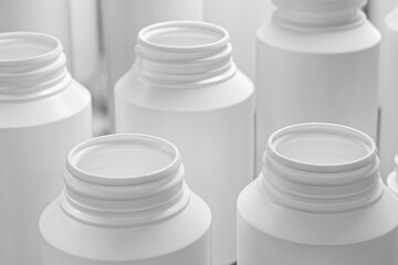 Empty unlabeled white plastic medicine jars