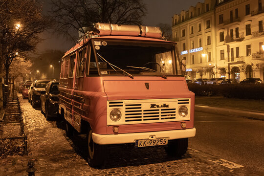 Krakow, Poland - November 30, 2025: Vintage Zuk van parked on cobblestone street at night near Hotel Sapienza, highlighting atmospheric urban charm