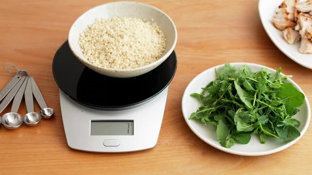 Measuring ingredients: hands prepare salad with lettuce, mushrooms, grains on scale in kitchen