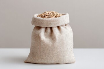 A small burlap sack overflowing with golden grains on a white surface