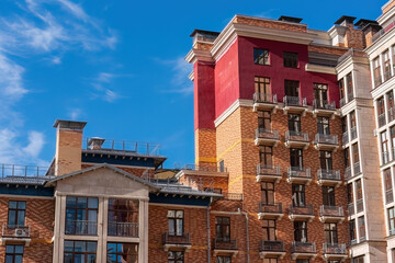 section of a modern residential building complex under a clear blue sky with wispy clouds