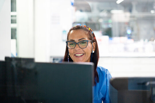 Smiling woman working on computer in office setting