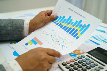 Asian business woman working with financial graph.
