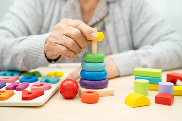 Asian elderly woman playing game.